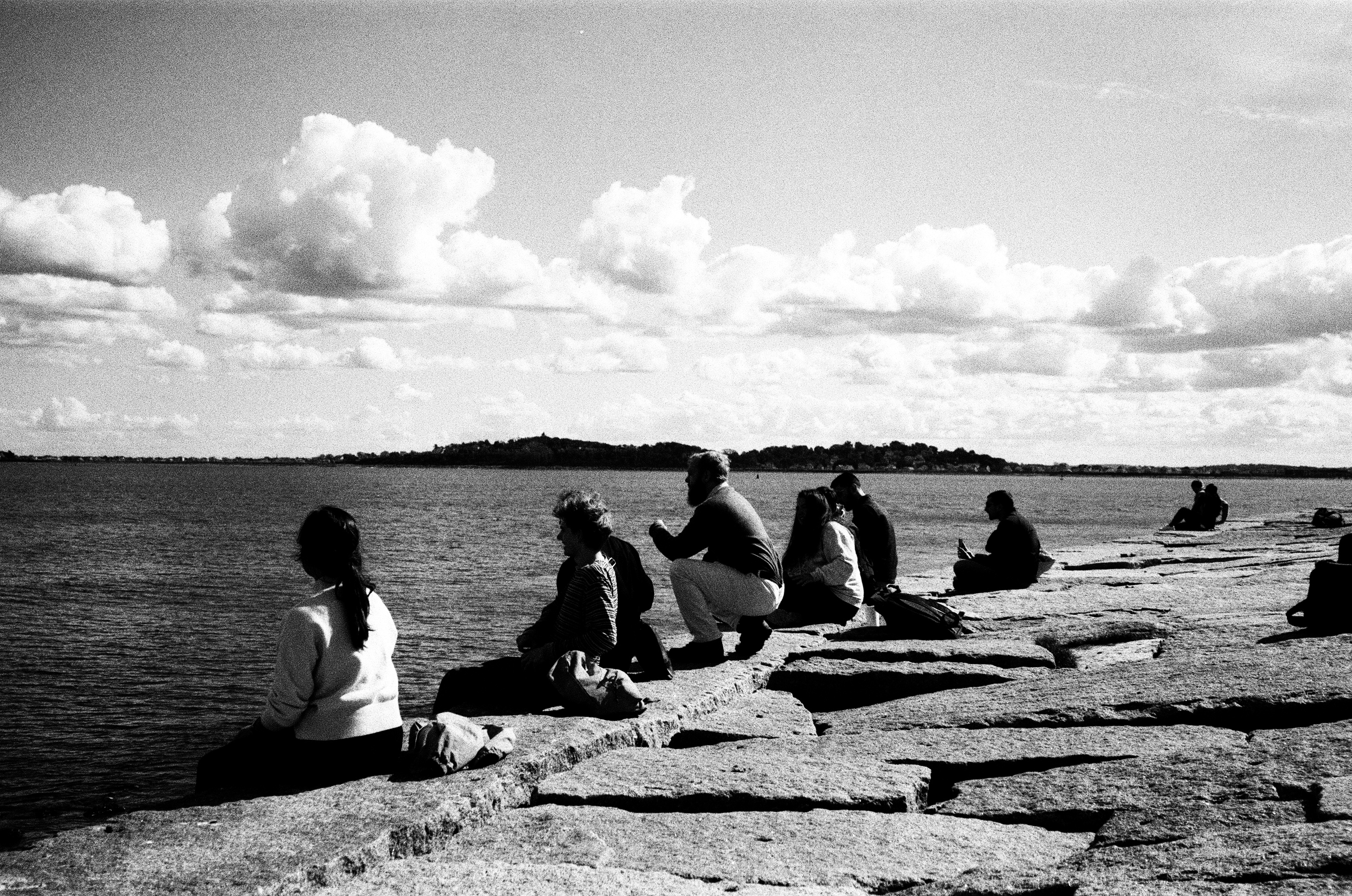 People sitting on rocks by the sea